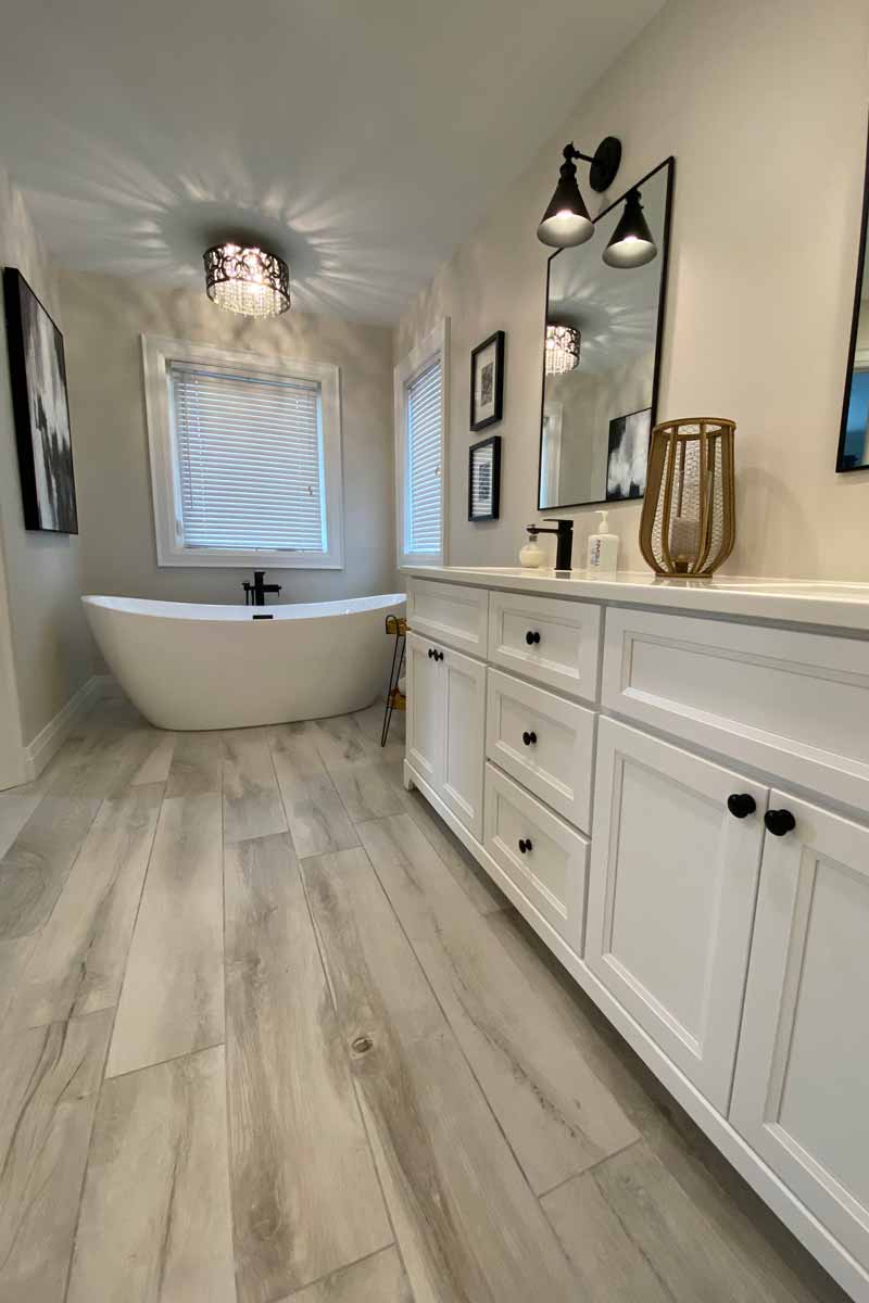 Beautifully renovated bathroom with tub and lighting