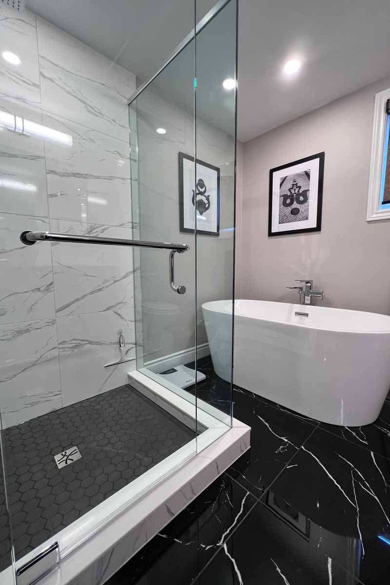 Finished bathroom with stylish tub and glass shower.