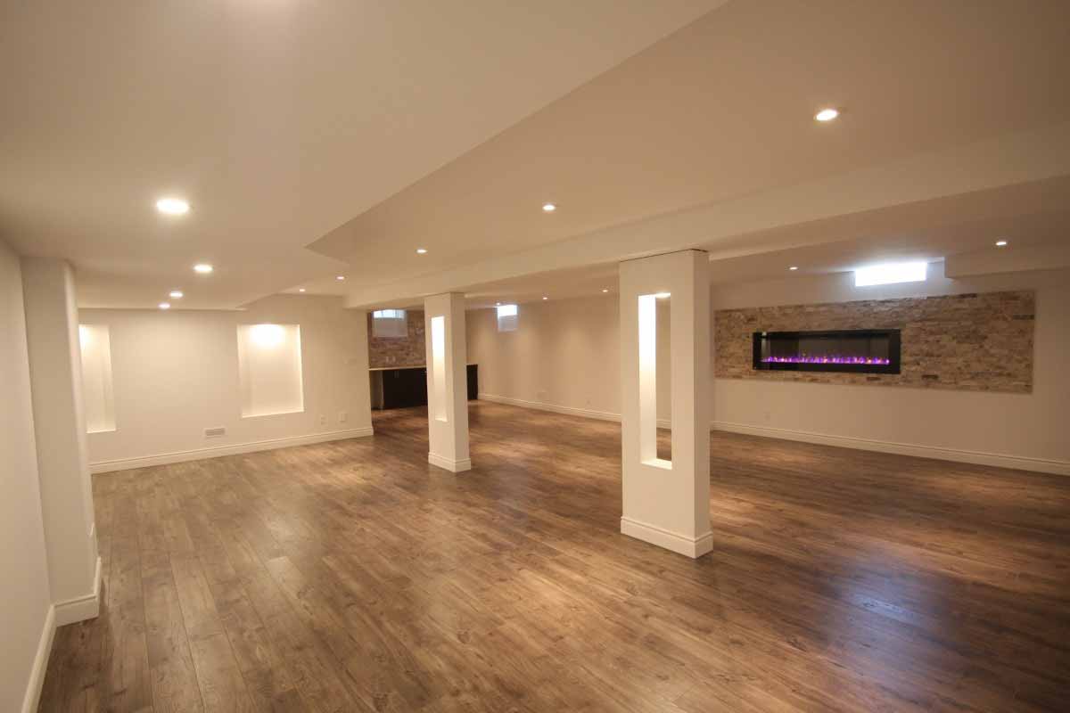 Large finished basement with brick facade, fireplace and wood flooring